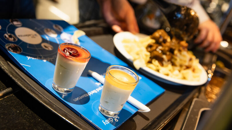 Dessertgläser und Teller mit warmem Essen am Buffet beim Disy Werkstattgespräch 2026.