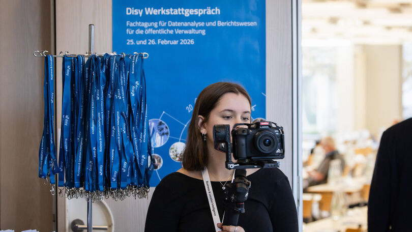 Videodokumentation des Disy Werkstattgesprächs 2026 durch eine Kamerafrau im Eingangsbereich.