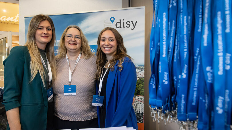 Mitarbeiterinnen von Disy am Empfangsbereich des Disy Werkstattgesprächs 20266 mit Namensschildern und Teilnehmerbändern.